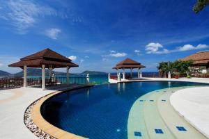 a swimming pool with two gazebos next to the water at Villa Suriya B2 in Patong Beach