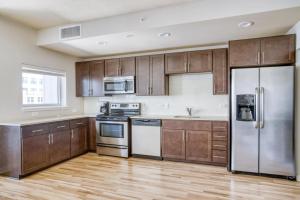 a kitchen with wooden cabinets and stainless steel appliances at LoDo 1BR w WD Pool Gym nr Union Station DEN-152 in Denver