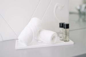 a shelf with toilet paper and cosmetics on it at Château de l'Aile- Boutique Suites in Vevey +58 photos