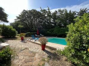 a swimming pool in a yard with potted plants at Villa Caprier in Le Pradet