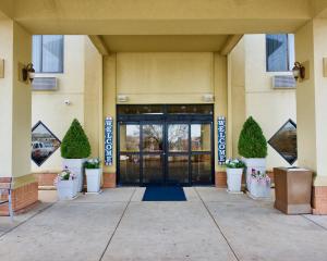 einer Eingangstür eines Gebäudes mit Topfpflanzen in der Unterkunft Holiday Inn Express Hotel & Suites Fenton/I-44, an IHG Hotel in Fenton