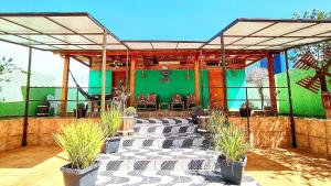 a patio with chairs and a green wall at Studios prox Cataratas e Aduana Argentina in Foz do Iguaçu