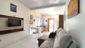 ein Wohnzimmer mit einem Sofa und einem Flachbild-TV in der Unterkunft Studios prox Cataratas e Aduana Argentina in Foz do Iguaçu