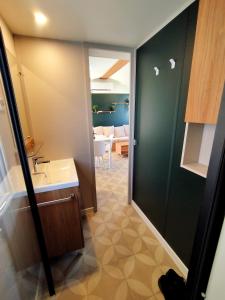 a bathroom with a sink and a tub and a room at Mobil-Home Eucalyptus Valras-Plage in Valras-Plage