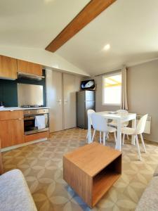 a living room with a table and a kitchen at Mobil-Home Eucalyptus Valras-Plage in Valras-Plage