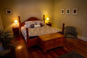 a bedroom with a bed and a chair and two lamps at Tizzana Winery Bed and Breakfast in Sackville Reach