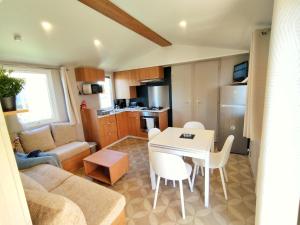 a living room with a couch and a table at Mobil-Home Eucalyptus Valras-Plage in Valras-Plage