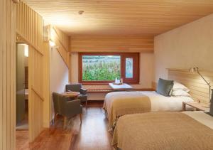 a hotel room with two beds and a window at Explora Valle Sagrado in Urubamba