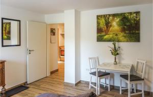 a dining room with a table and a painting on the wall at Gorgeous Apartment In Loxstedt With Kitchen in Loxstedt