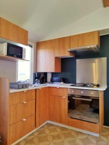 a kitchen with wooden cabinets and a stove top oven at Mobil-Home Eucalyptus Valras-Plage in Valras-Plage
