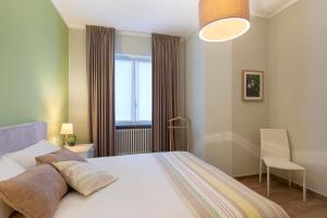 a bedroom with a white bed and a window at Bellavista Apartments - By Impero House in Levo