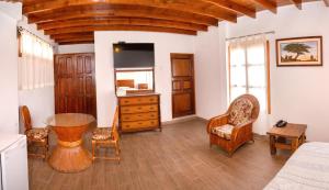 a bedroom with a table and chairs and a dresser at Bodega el Huarango in Ica