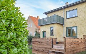 a house with a wooden fence in front of it at 4 Bedroom Lovely Home In Bandholm in Bandholm +9 photos