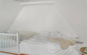 - un lit bébé blanc dans une chambre dotée d'un mur blanc dans l'établissement 1 Bedroom Beautiful Apartment In Sejer, à Sejerby