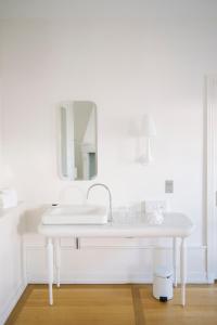 a white bathroom with a sink and a mirror at Le Château de l'Aile in Vevey