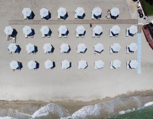 an overhead view of a beach with chairs and umbrellas at Hotel Golden Sun in Nea Mesangala