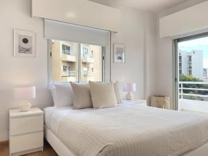 a white bedroom with a large bed and a window at Phaedrus Living Down Town Flat Nestoras 301 in Limassol