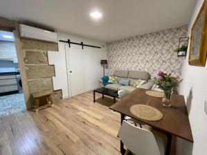 a living room with a table and a couch at A Fonte -Acogedor apartamento en pleno centro de Ourense in Ourense +17 photos