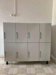 a group of white lockers in a room at Fica, Vai ter Bolo Hostel in Itajaí