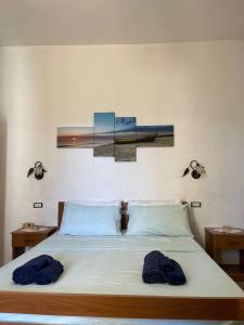 a bedroom with a bed with two blue towels on it at Dimora Mimmi Marina di Mancaversa - Gallipoli in Marina di Mancaversa