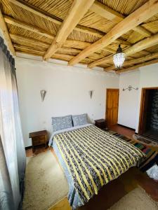 ein Schlafzimmer mit einem Bett und einer Holzdecke in der Unterkunft Hiking Nomads Guesthouse in Tamellalt