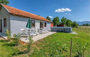 a group of chairs and an umbrella in front of a house at Cozy Home In Debelo Brdo I With Wifi in Debelo Brdo