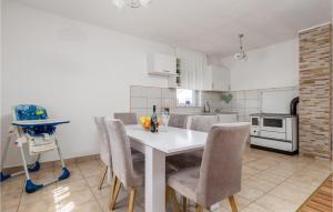 una cucina con un tavolo bianco e sedie in una stanza di Beautiful Home In Debelo Brdo I a Debelo Brdo