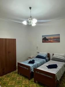a bedroom with two beds and a ceiling fan at Dimora Mimmi Marina di Mancaversa - Gallipoli in Marina di Mancaversa