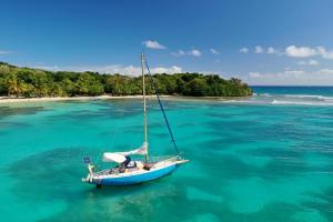 a boat floating in the water near a beach at plage et spot de surf in Le Gosier