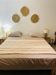 a bed with two pillows and two baskets on the wall at plage et spot de surf in Le Gosier
