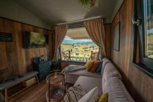 ein Wohnzimmer mit einem Sofa und einem Fenster in der Unterkunft Tripsylvania Tiny House in Şirnea