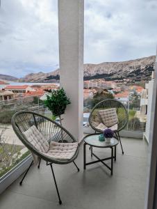 two chairs and a table on a balcony with a view at King's Apartment in Baška