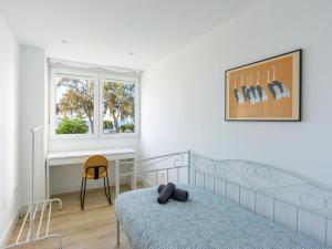 1 dormitorio con cama, escritorio y ventana en Sea View with Parking by LU&CIA en Málaga