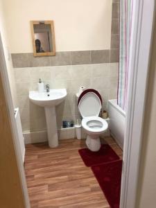 a bathroom with a toilet and a sink at JustAlf Facilities-Spacious 2-bed apartment in Thamesmead, Greenwich in London