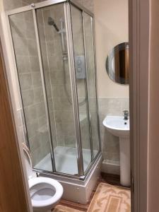 ein Bad mit einer Dusche, einem WC und einem Waschbecken in der Unterkunft JustAlf Facilities-Spacious 2-bed apartment in Thamesmead, Greenwich in London