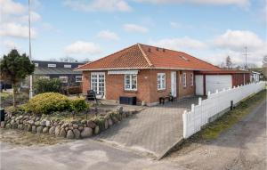 a brick house with a white fence in front of it at 3 Bedroom Gorgeous Home In Broager in Broager +29 photos