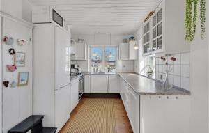 a white kitchen with white cabinets and a window at 3 Bedroom Gorgeous Home In Broager in Broager