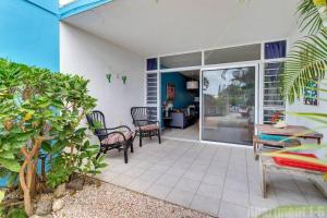 un patio con sillas, mesa y mesa en Bonaire Oceanfront Apartments, en Kralendijk