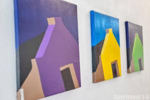 three paintings of vases hanging on a wall at Bonaire Oceanfront Apartments in Kralendijk