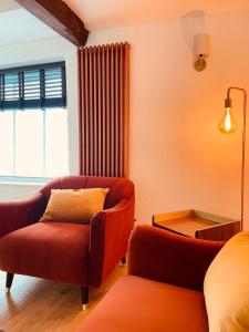a living room with a couch and a chair at Abbey Gardens Cottage in Bury Saint Edmunds