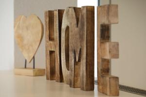 a wooden sign that says love with a heart at Appartement Deluxe by Fam. Steiert in Schwanau