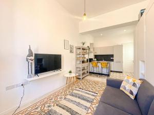 a living room with a couch and a tv at Entire Studio Apartment in Sliema 2A By Solea in Sliema