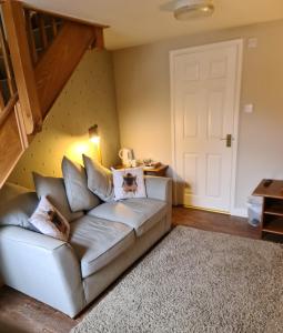 a living room with a couch and a staircase at Newditch Farm Accommodation in Bristol