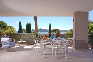 een tafel en stoelen op een patio met uitzicht op het water bij Lamasu RioVerde - Lago di Garda in San Felice del Benaco