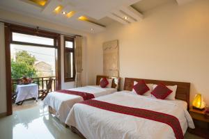 
a hotel room with two beds and two lamps at Hoang Thu Homestay in Hoi An

