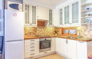 een keuken met witte kasten en een witte koelkast bij 2 Bedroom Cozy Home In Orihuela in Orihuela