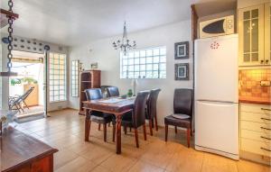 een keuken met een tafel, stoelen en een koelkast bij 2 Bedroom Cozy Home In Orihuela in Orihuela