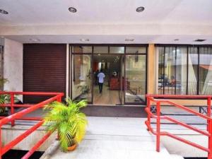 un edificio con dos bancos rojos frente a un edificio en Hotel Srinivas, en Kochi