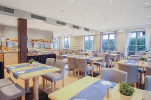 ein Restaurant mit Tischen und Stühlen und eine Cafeteria in der Unterkunft Inselhotel Poel in Gollwitz