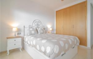 a white bedroom with a bed and a wooden cabinet at Stunning Apartment In Rincn De La Victoria With Kitchen in Rincón de la Victoria